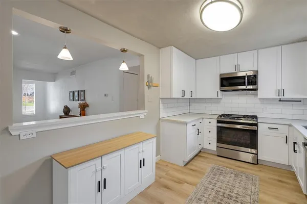 a kitchen with cabinets stainless steel appliances and a sink