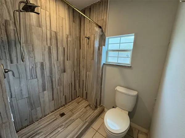 a white toilet sitting next to a shower curtain