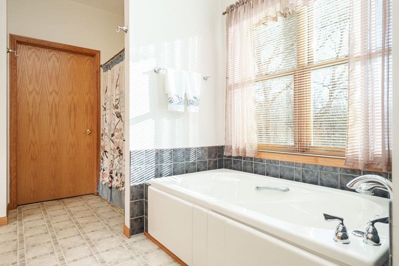 19905 State Line Road Harvard, IL 60033 - Photo 21 of 55 a white bath tub sitting in a bathroom next to a window