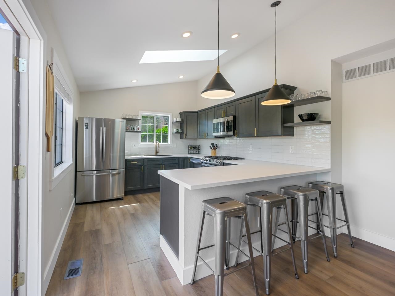 383 Explorer Court, Unit B Grand Junction, CO 81507 - Photo 12 of 40 a kitchen with a table a refrigerator a sink a stove and a wooden floor
