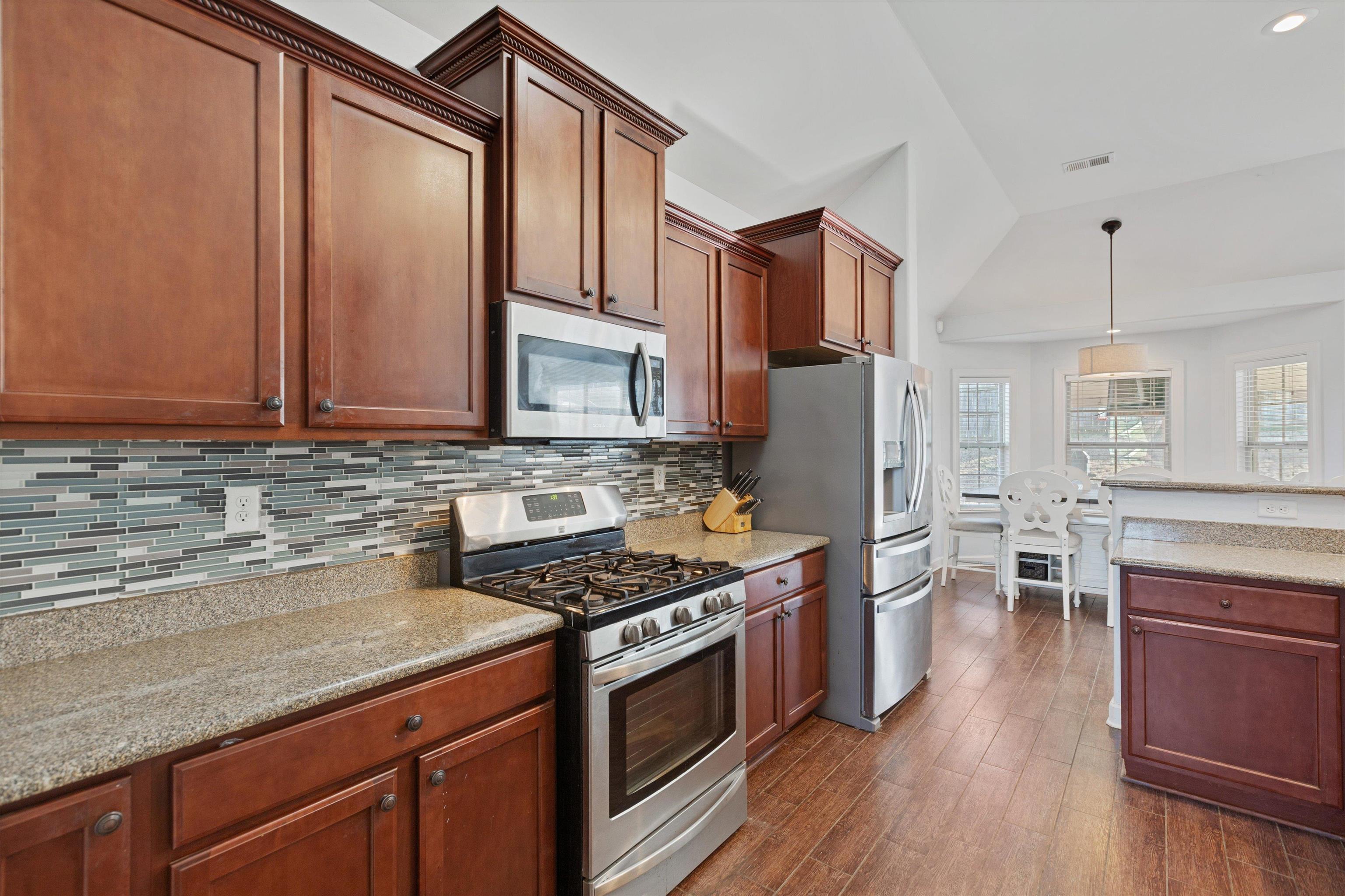 6005 Maher Valley Cove Bartlett, TN 38135 - Photo 14 of 28 a kitchen with stainless steel appliances granite countertop a stove top oven a sink dishwasher a refrigerator and cabinets with wooden floor