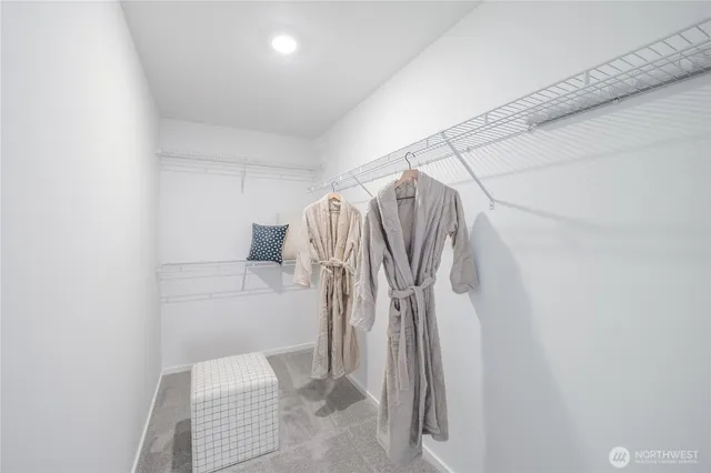 a view of walk in closet with clothes