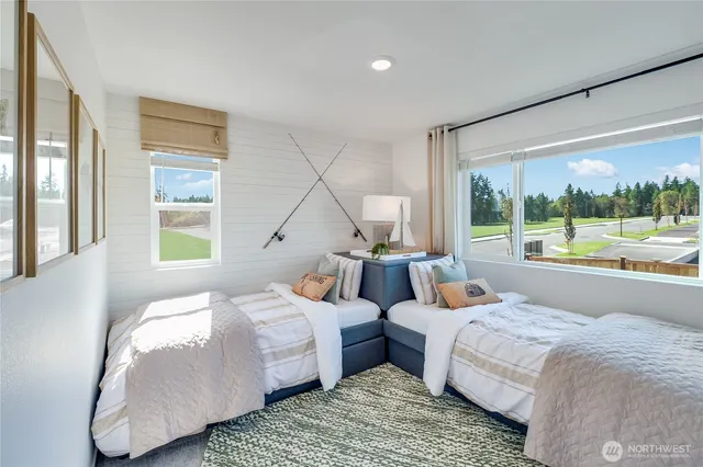 a bedroom with two beds and large windows