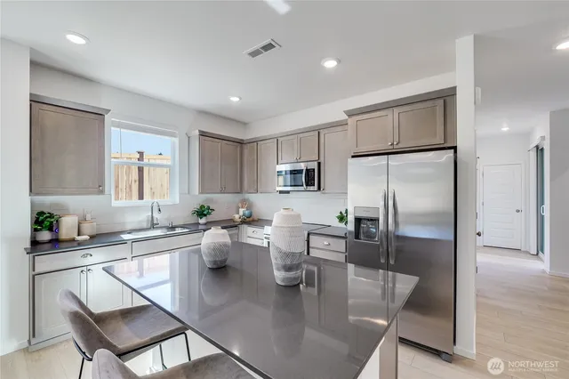 a kitchen with a dining table chairs refrigerator and cabinets