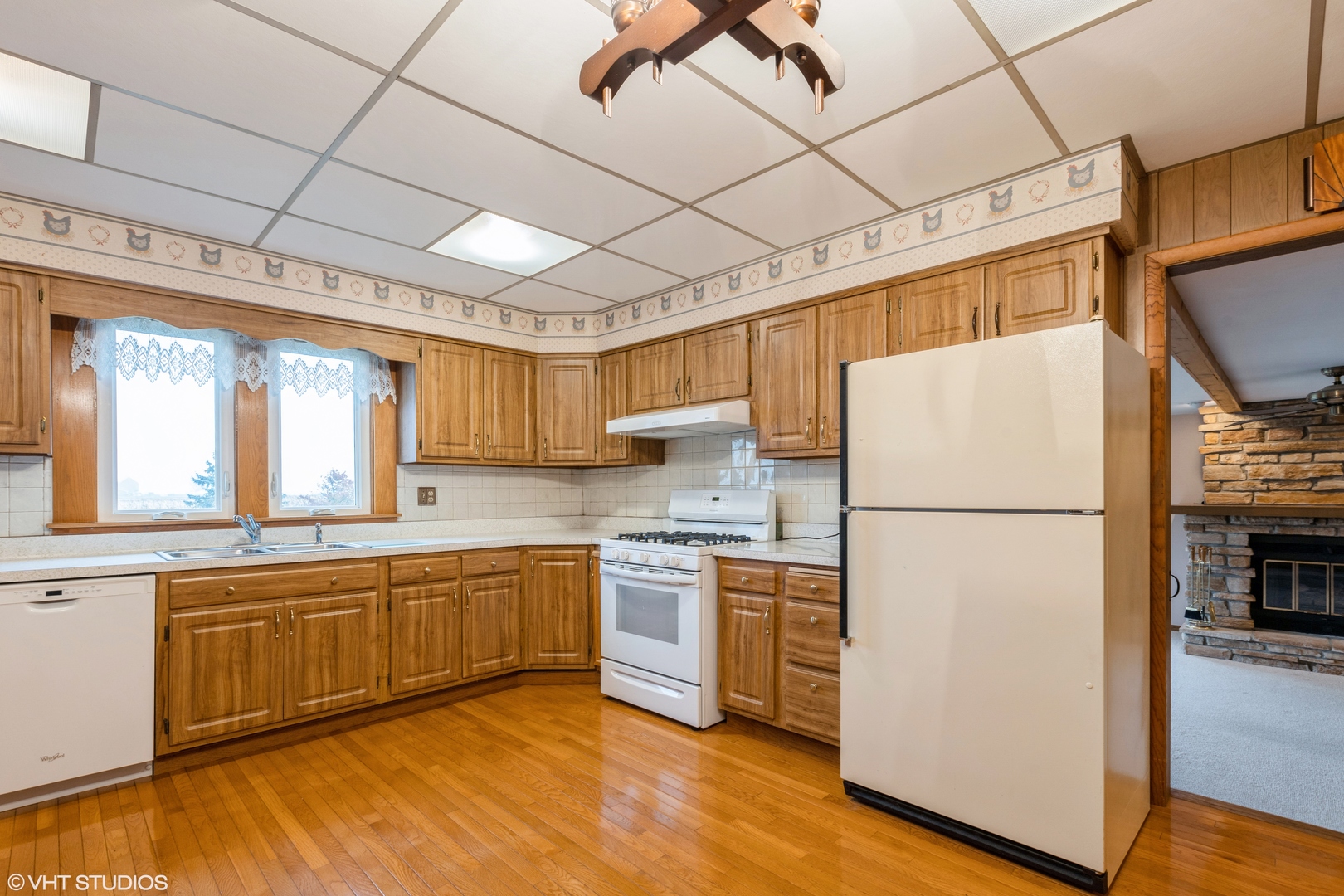 6222 Rich Road DeKalb, IL 60115 - Photo 6 of 31 a kitchen with a refrigerator a stove a sink wooden floor and cabinets