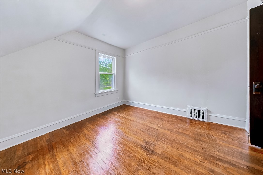 24958 Kennedy Ridge Road North Olmsted, OH 44070 - Photo 23 of 43 Hardwood flooring, bright window, white trim, and a dark wood door