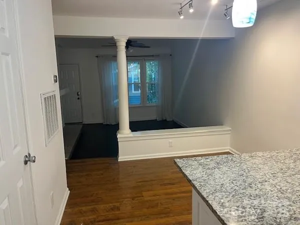 a room with wooden floor and chandelier