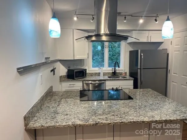 a kitchen with stainless steel appliances granite countertop a sink a stove and a refrigerator