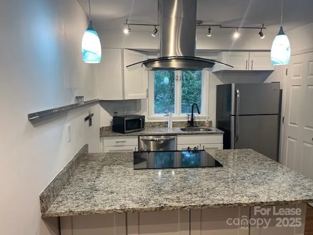 a kitchen with stainless steel appliances granite countertop a sink a stove and a refrigerator