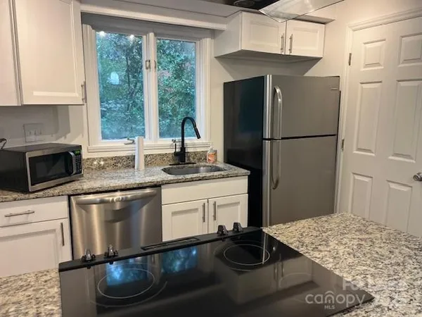 a kitchen with a refrigerator sink and stove