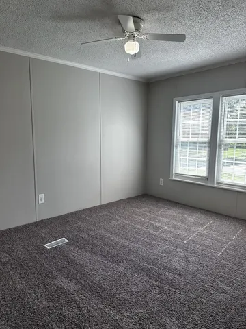 en empty room with windows and ceiling fan