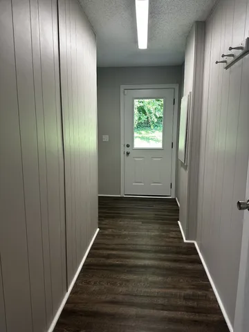 a view of a hallway with wooden floor and staircase