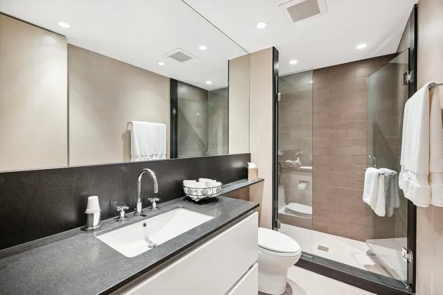 a bathroom with a sink a toilet and shower