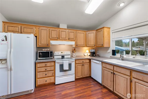 a kitchen with stainless steel appliances granite countertop a refrigerator sink and white cabinets