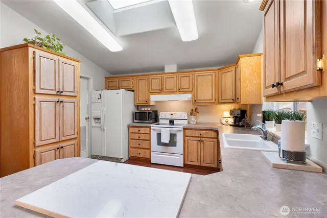 a kitchen with a refrigerator sink and cabinets