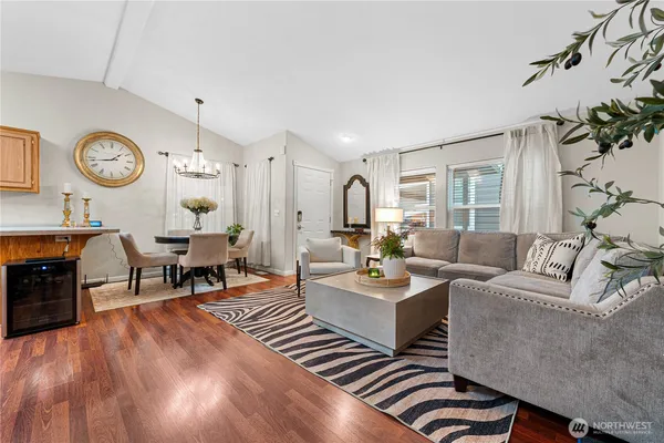 a living room with furniture kitchen view and a large window