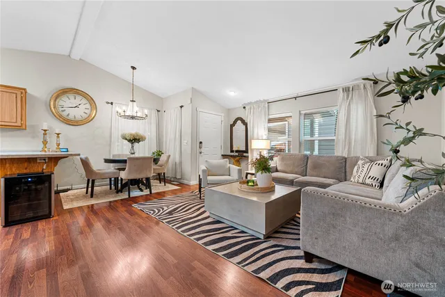 a living room with furniture kitchen view and a large window