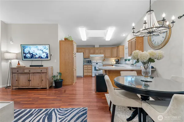 a dining room filled chandelier and wooden floor