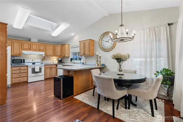 a view of a dining room and livingroom with furniture wooden floor a chandelier