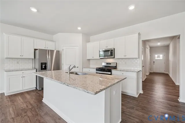 a kitchen with a center island appliances and cabinets