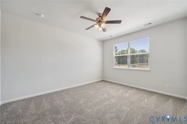 an empty room with window and ceiling fan