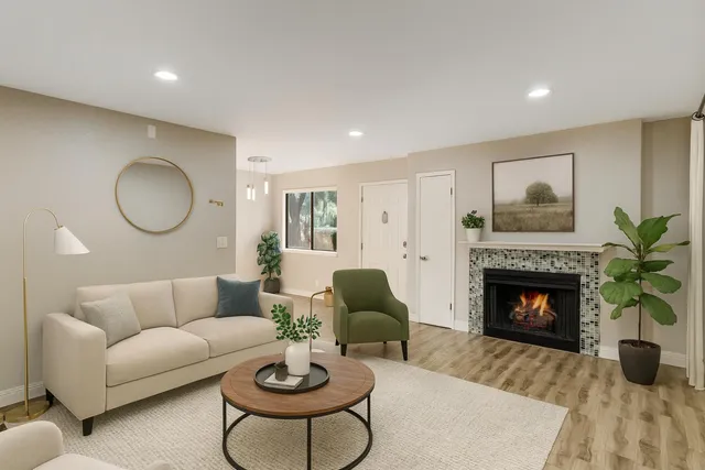a view of an empty room with wooden floor fireplace and a window
