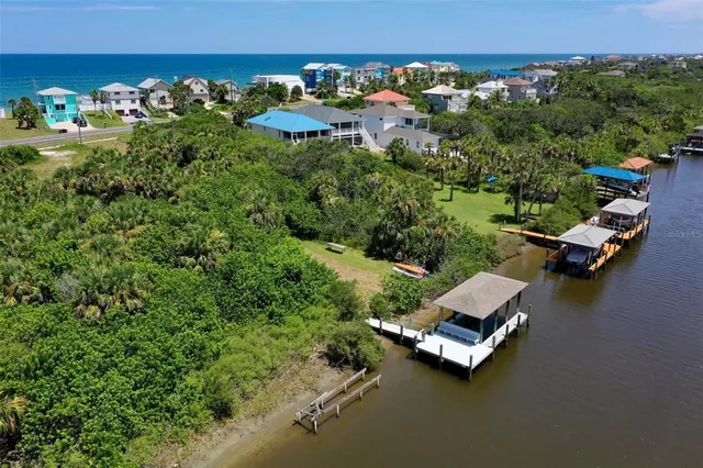 an aerial view of a house with a yard and lake view
