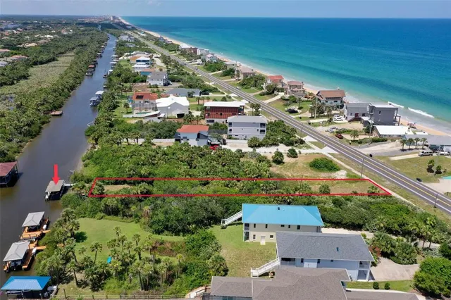 an aerial view of a city with lots of residential buildings ocean and mountain view in back