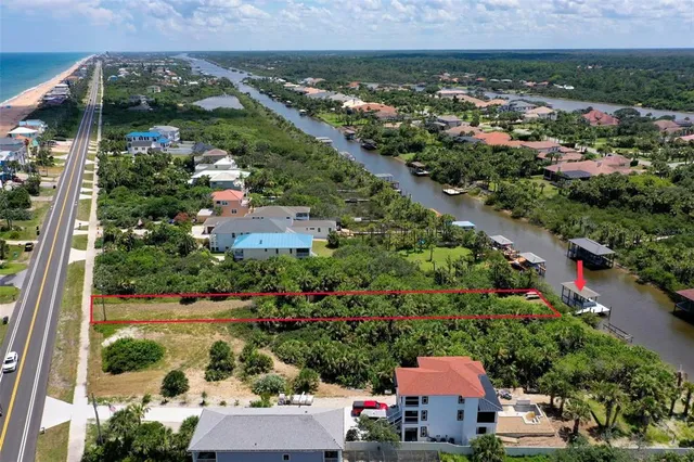 an aerial view of residential houses with outdoor space and trees