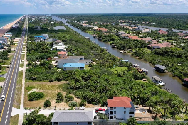 an aerial view of residential houses with outdoor space and trees