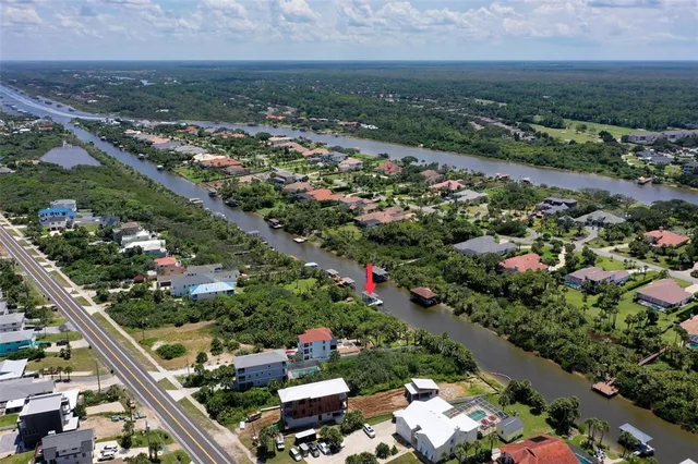 an aerial view of residential houses with outdoor space and trees