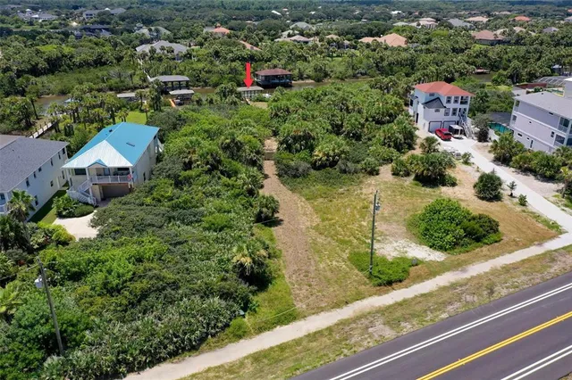 an aerial view of residential house with outdoor space and trees all around