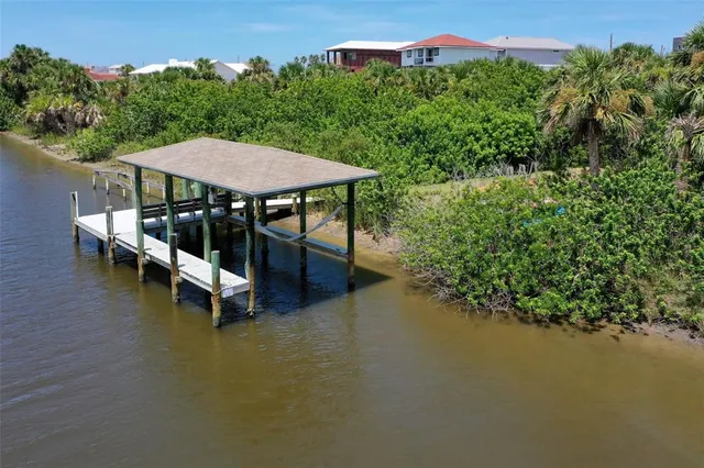 a view of a patio with table and chairs under an umbrella next to a yard