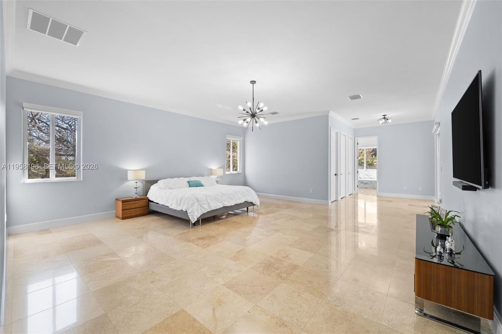 16800 Southwest 190th Street Miami, FL 33187 - Photo 17 of 56 a spacious bedroom with a bed and a flat screen tv