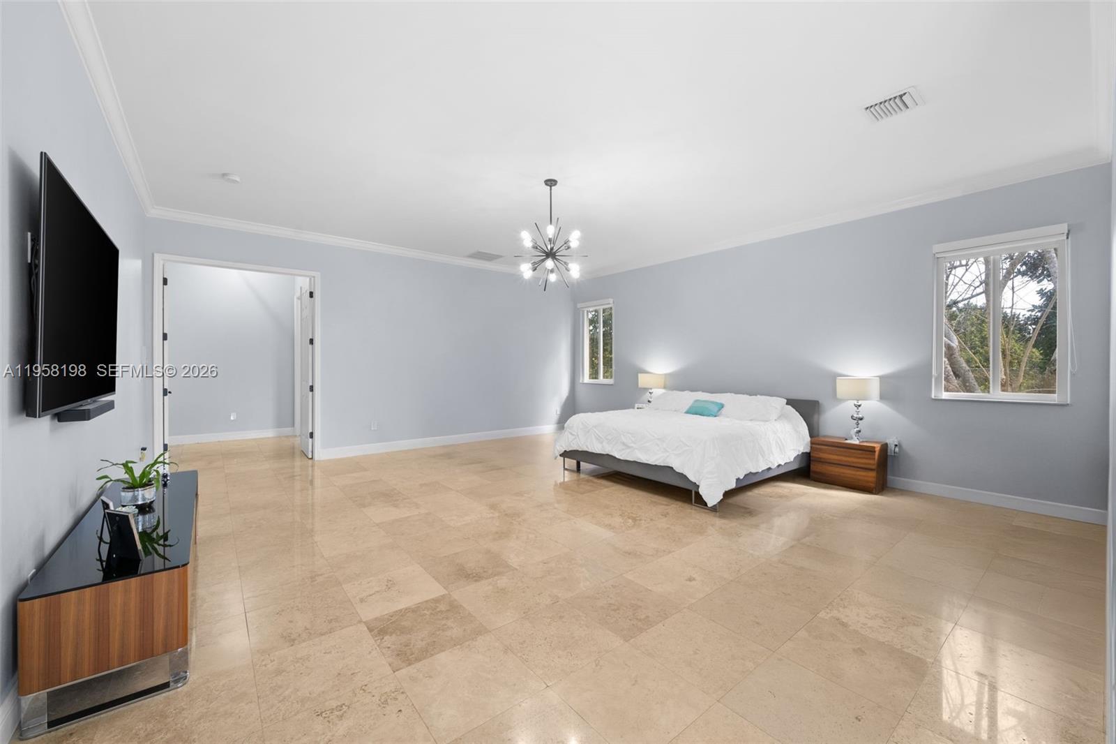 16800 Southwest 190th Street Miami, FL 33187 - Photo 18 of 56 a spacious bedroom with a bed and a flat screen tv