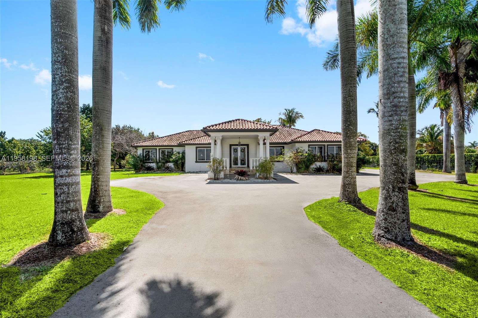 16800 Southwest 190th Street Miami, FL 33187 - Photo 2 of 56 a front view of a house with yard and green space