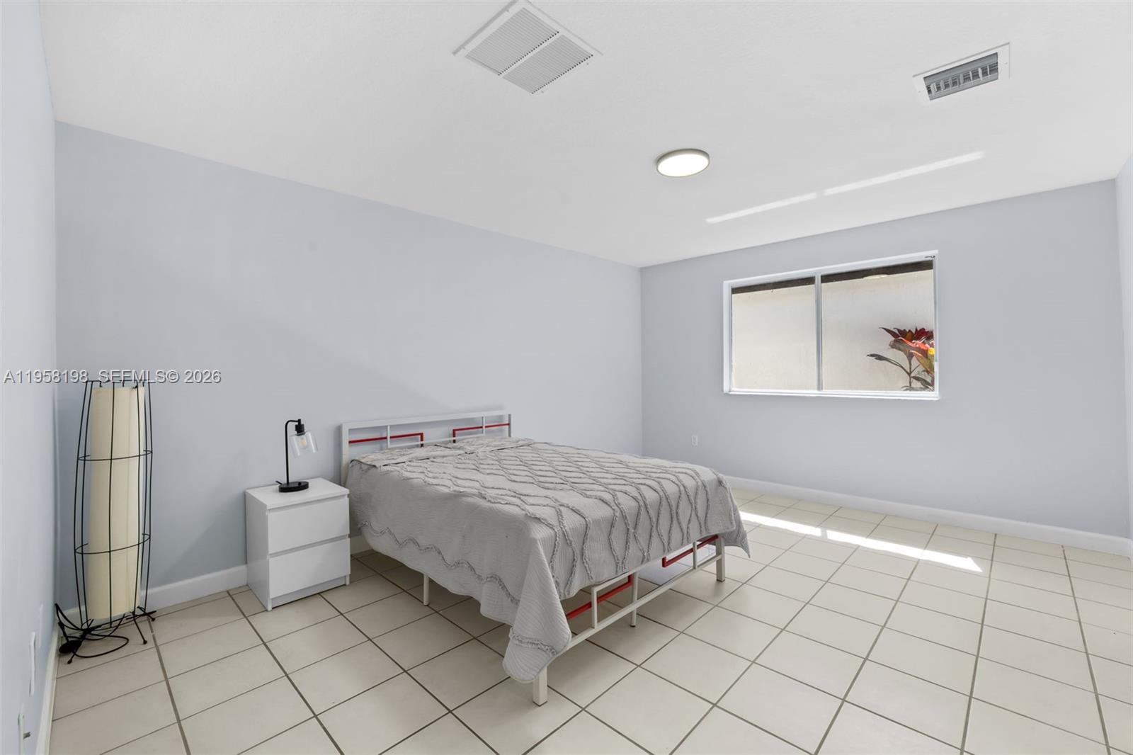 16800 Southwest 190th Street Miami, FL 33187 - Photo 49 of 56 a spacious bedroom with a bed and a window