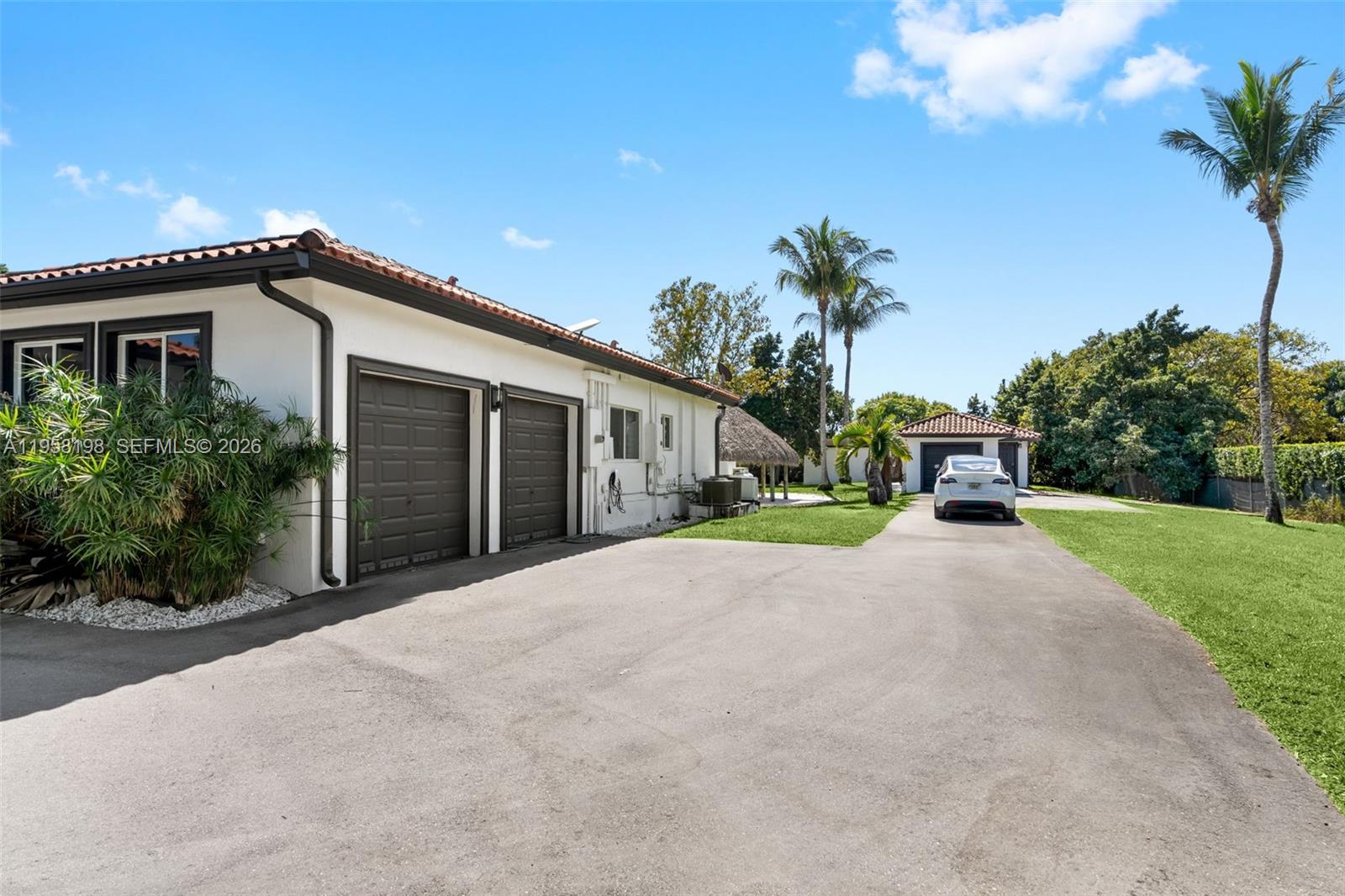 16800 Southwest 190th Street Miami, FL 33187 - Photo 6 of 56 a front view of a house with a yard and a garage