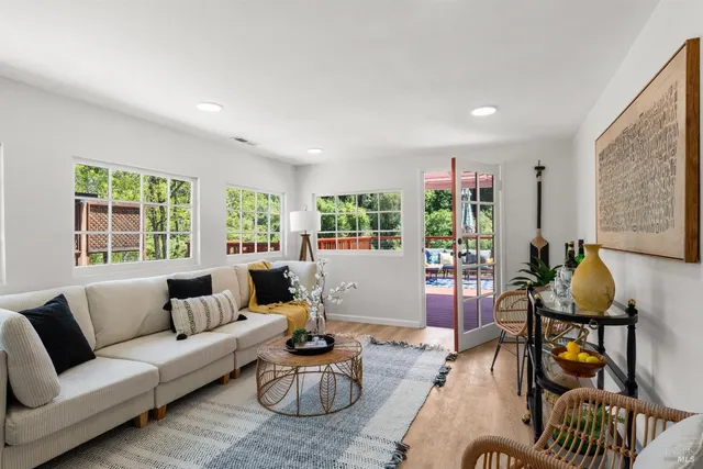 a deck with outdoor seating and trees in the background