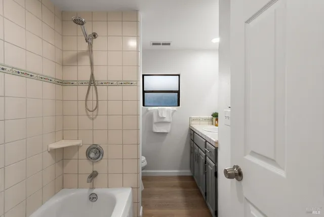 a bedroom with a bed a mirror and a table in it