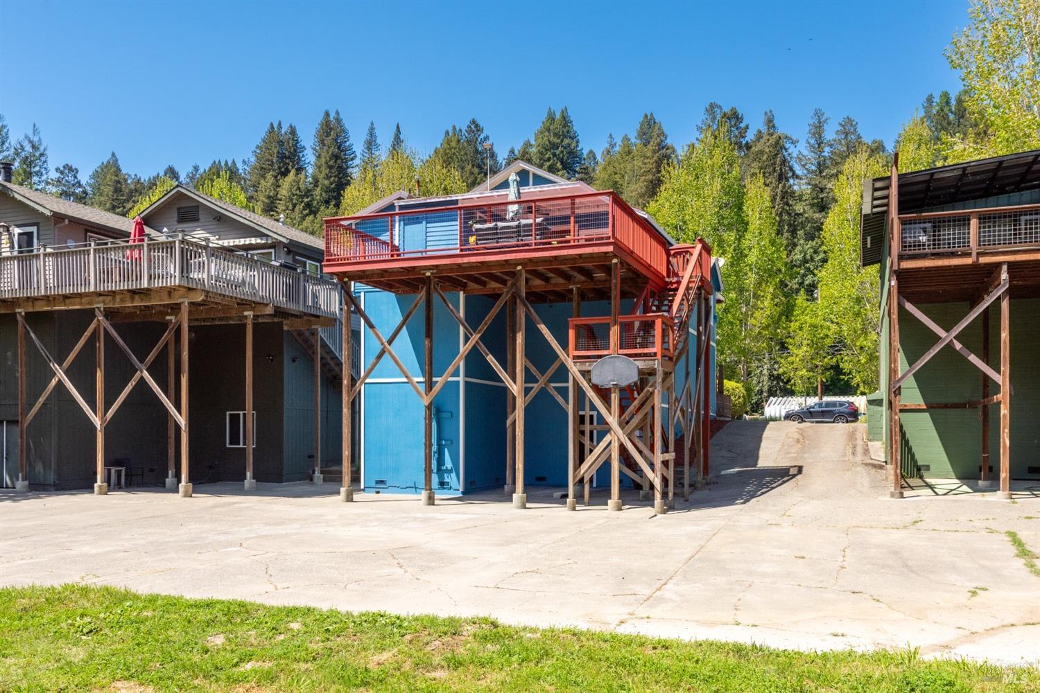 15627 Riverside Drive Guerneville, CA 95446 - Photo 33 of 41 a view of a house with wooden deck and furniture