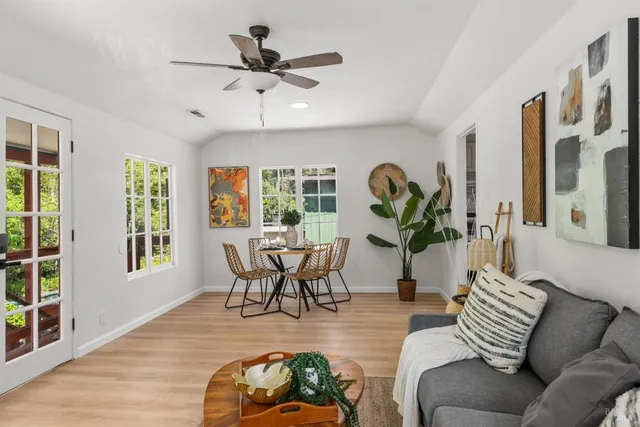 a living room with furniture a window and wooden floor