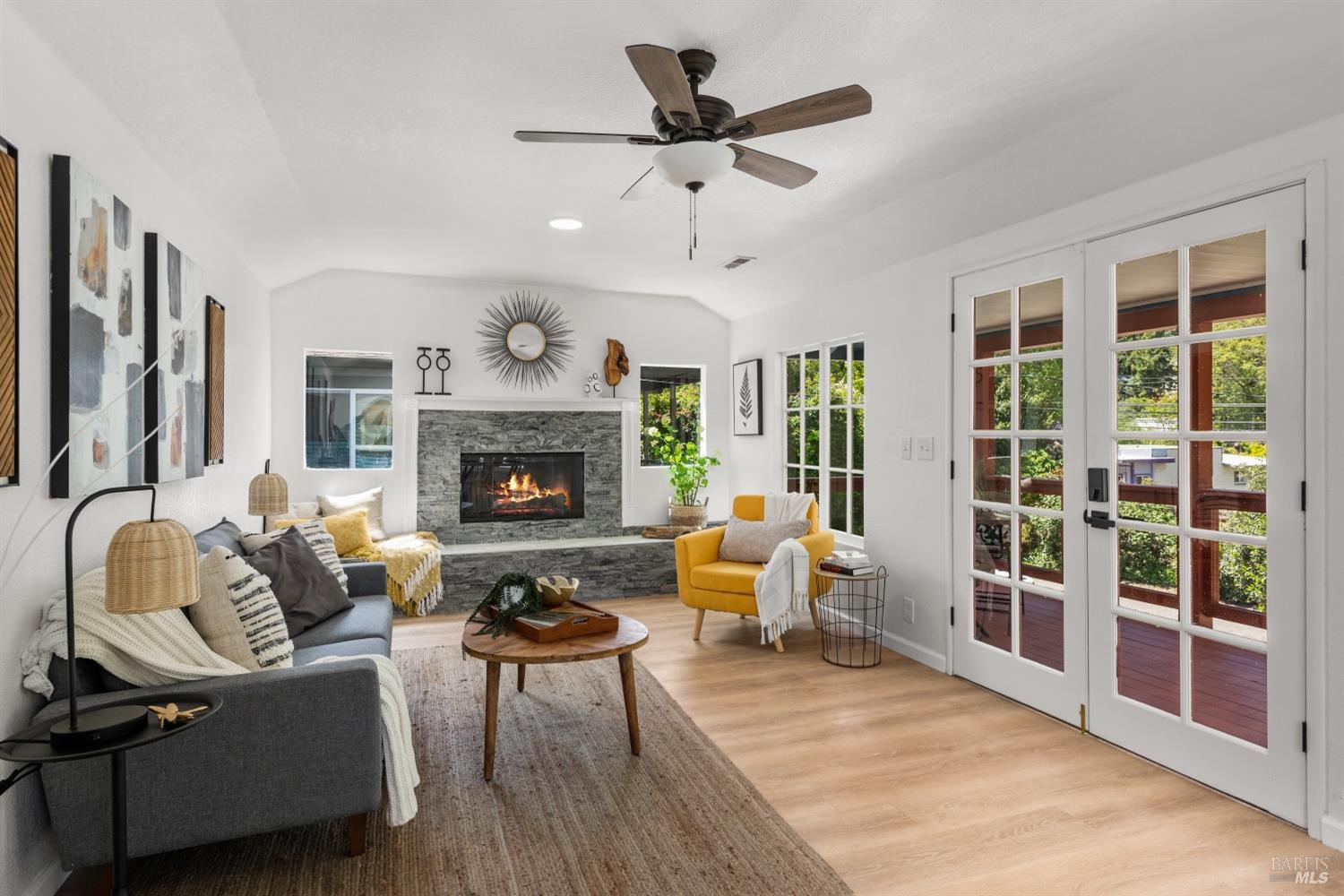 15627 Riverside Drive Guerneville, CA 95446 - Photo 10 of 41 a living room with furniture ceiling fan and a fireplace