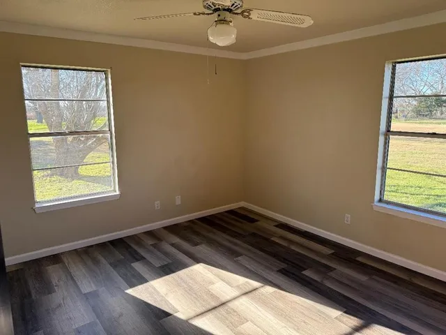 a view of a room with wooden floor and a window