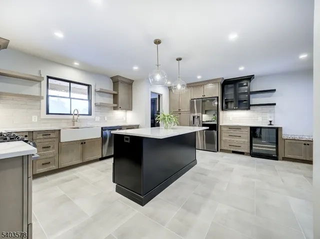 a kitchen with kitchen island granite countertop a sink cabinets and stainless steel appliances
