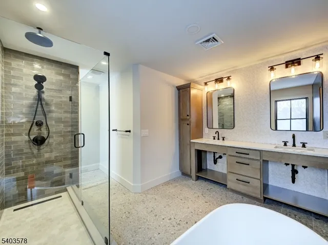 a bathroom with a double vanity sink mirror and bathtub