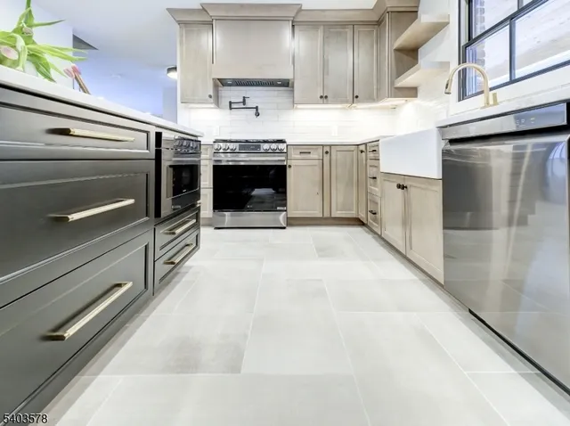 a kitchen with stainless steel appliances kitchen island granite countertop a stove and a sink