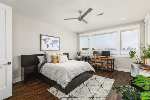 a bedroom with a bed a couch and a potted plant