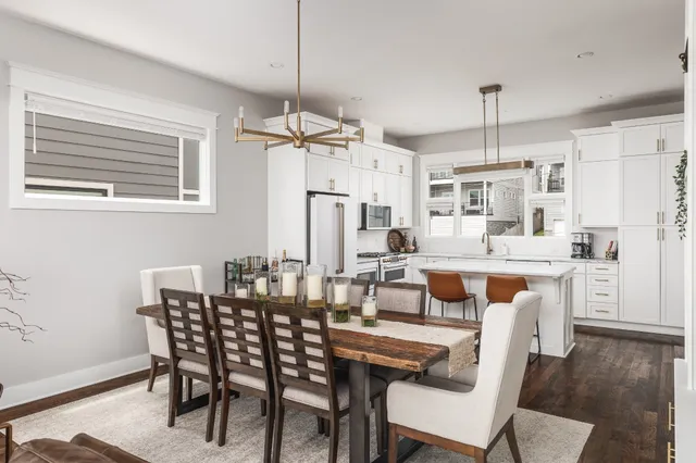 a dining room with stainless steel appliances kitchen island a table and chairs