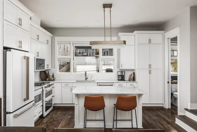 a kitchen with stainless steel appliances granite countertop a stove refrigerator and cabinets